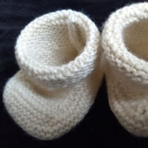 Soft white knitted baby bootees